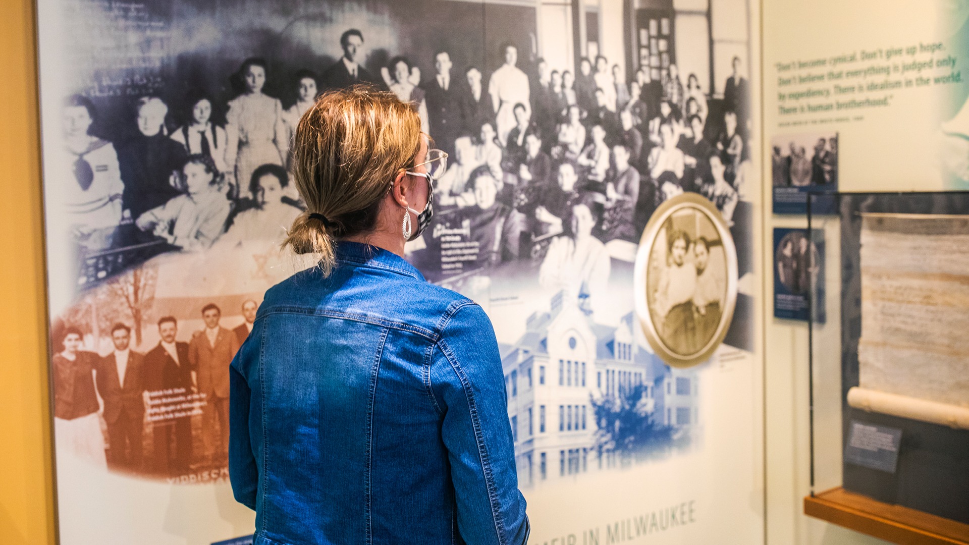 Visitor viewing a historical exhibit featuring early Milwaukee Jewish community photographs
