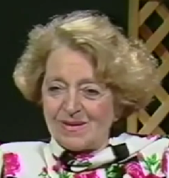 Marta Osvat Krantzthor, a Holocaust survivor, speaks expressively during a recorded interview wearing a bold floral jacket.