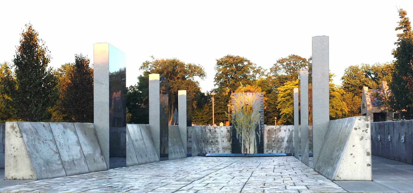 Entrance view of Pinat Hatikvah (Corner of Hope), HERC's outdoor contemplative space in Whitefish Bay featuring modern architectural design with tall pillars, reflecting panels, and concrete walls