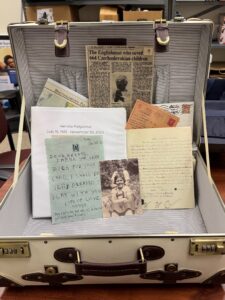 White vintage-style trunk filled with replica artifacts and educational materials from HERC's hands-on Survivor Trunk Program