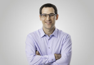 Michael Morris, Community Engagement Manager at HERC, smiling in a professional headshot, wearing glasses and a light purple button-down shirt.