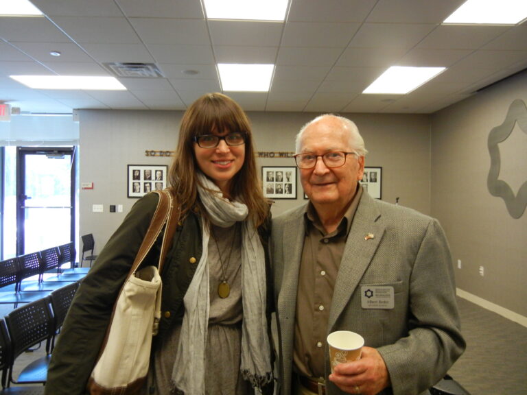 Old man poses with young woman with long brown hair